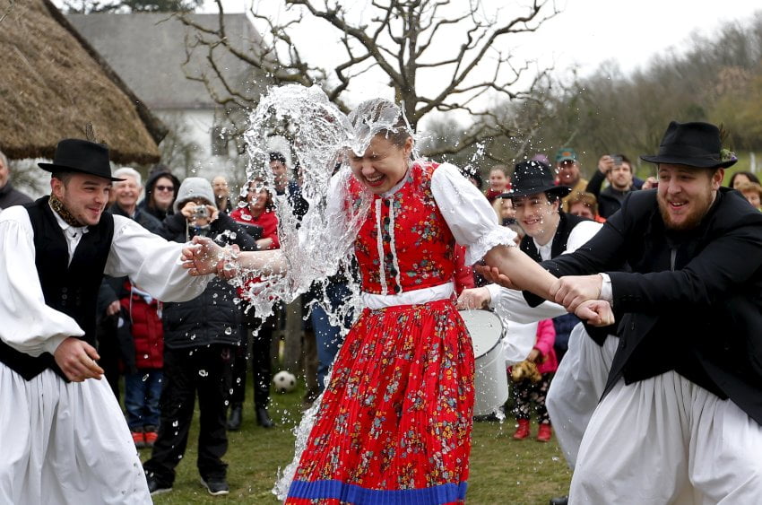 Men throw water on a woman as part of traditional Easter celebrations in Szenna